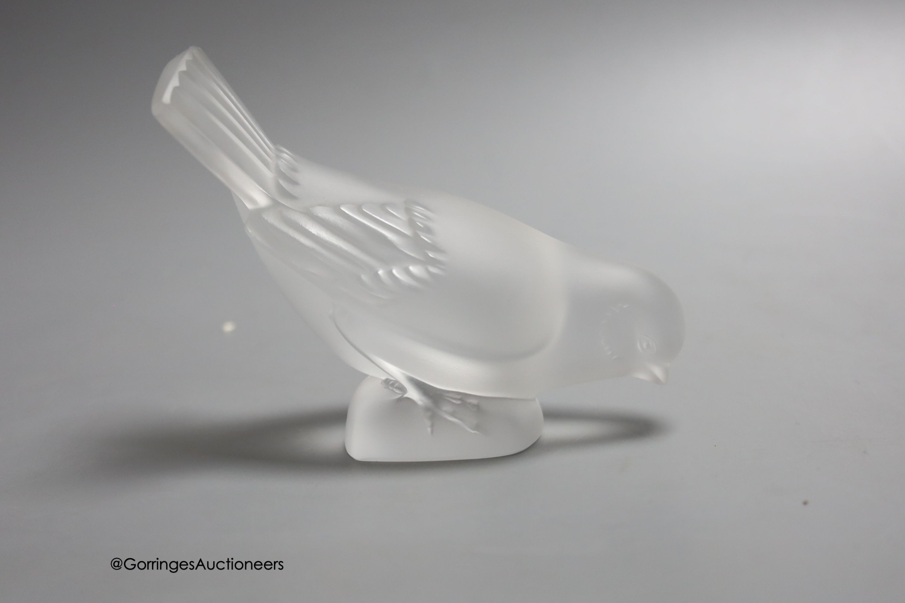 Two Lalique ashtrays mounted with birds, etched signatures to bases, and a Lalique style frosted glass bird paperweight